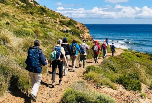 Menschen mit Rucksäcken, die entlang einer Küste wandern